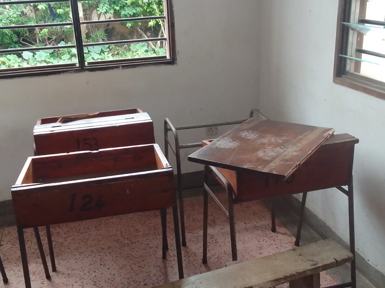 Close-up of damaged classroom desks