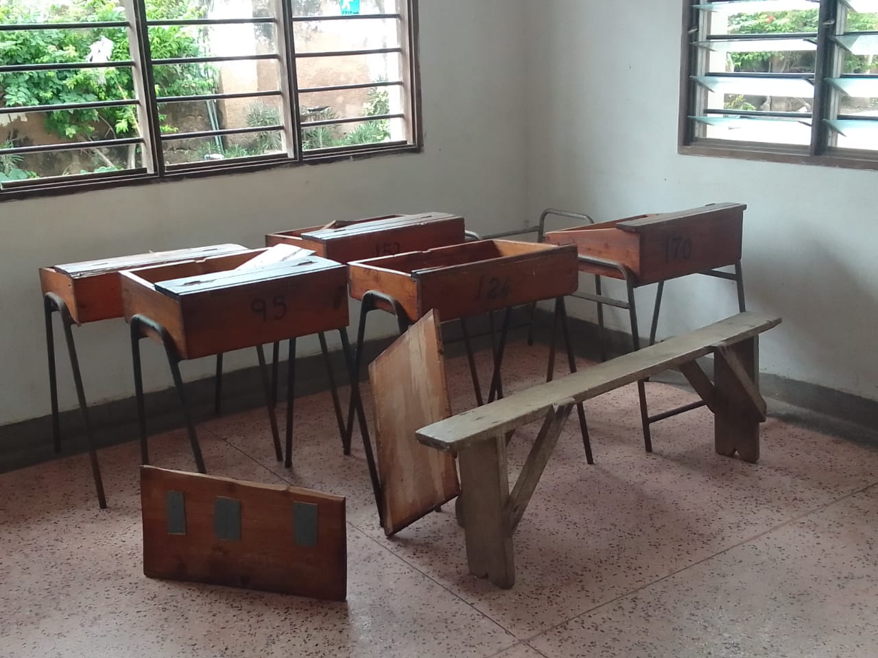 Close-up of damaged classroom desks
